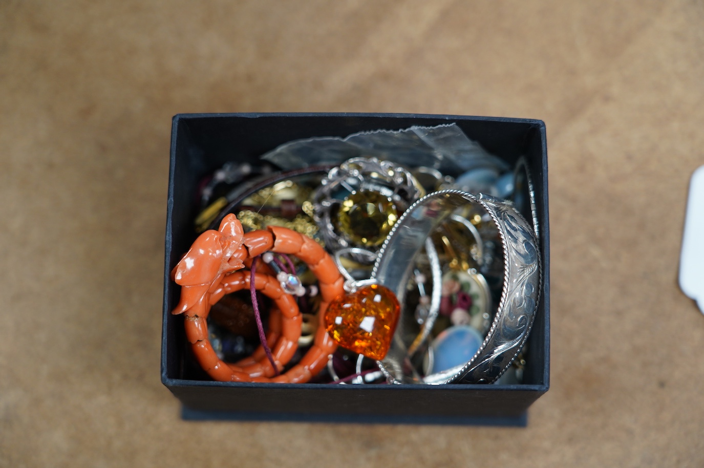 A small quantity of assorted jewellery including a coral set coiled dragon bracelet, a 1970's engraved silver hinged bangle, a Scottish silver and citrine brooch and costume. Condition - poor to fair to good